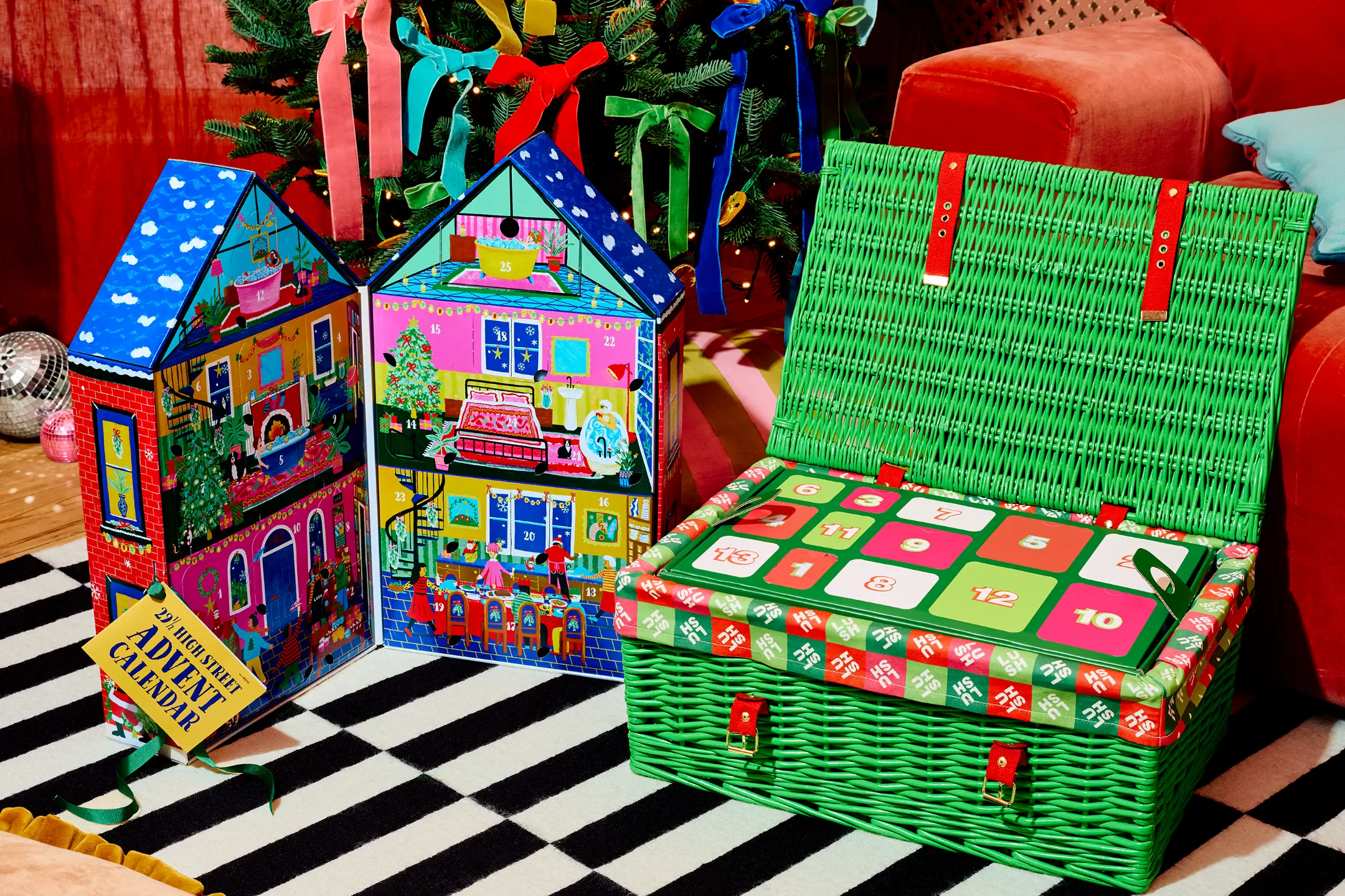 Colorful advent calendars designed by Lush, featuring a festive house and a green wicker basket, on a striped rug.