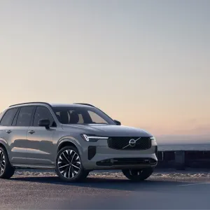 2026 Volvo XC90 T8 Ultra showcased from the front right in a coastal setting with a serene background.