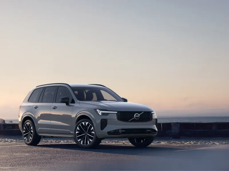 2026 Volvo XC90 T8 Ultra showcased from the front right in a coastal setting with a serene background.
