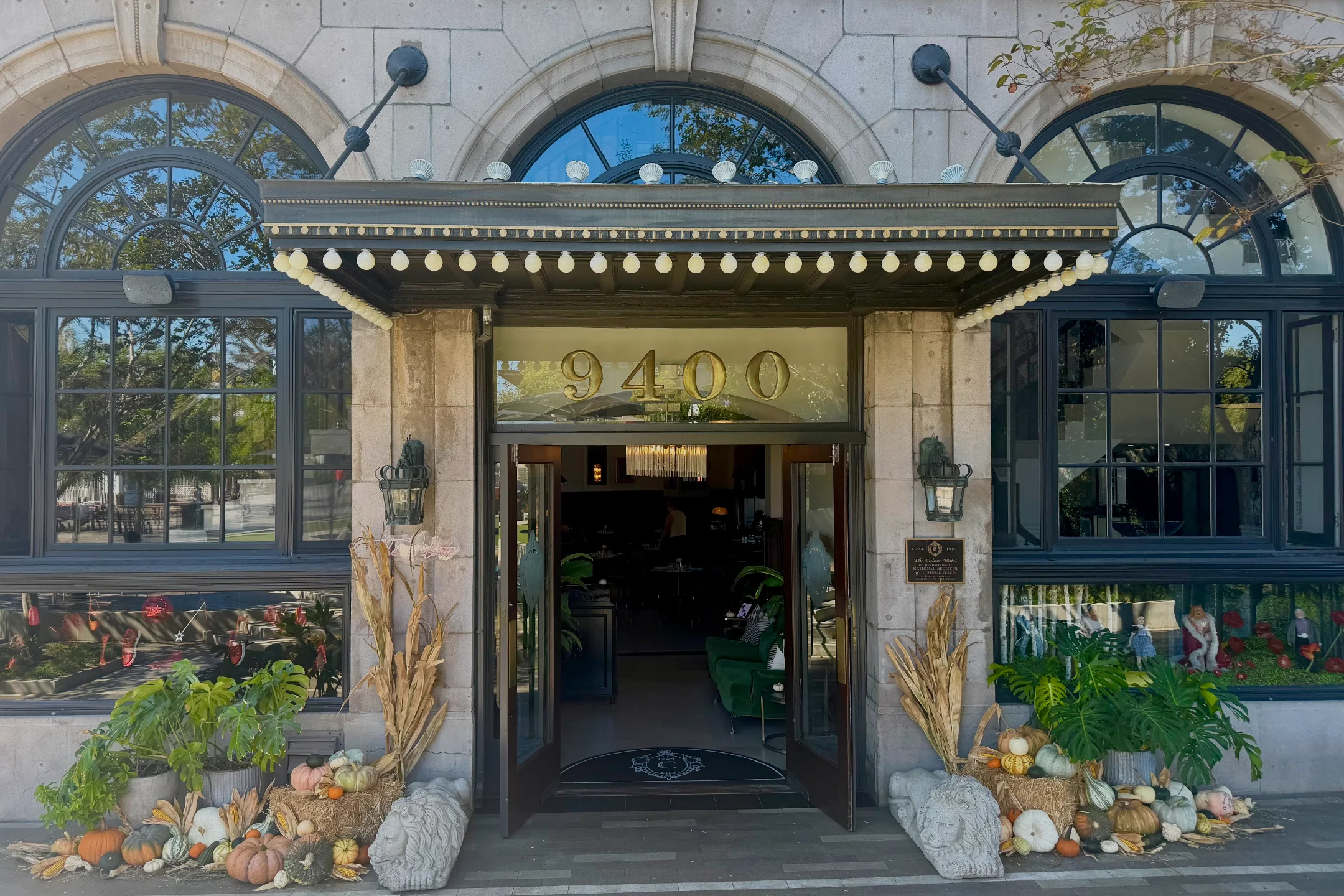 The entrance of the Culver Hotel decorated with pumpkins and cornstalks for a gothic Halloween theme.