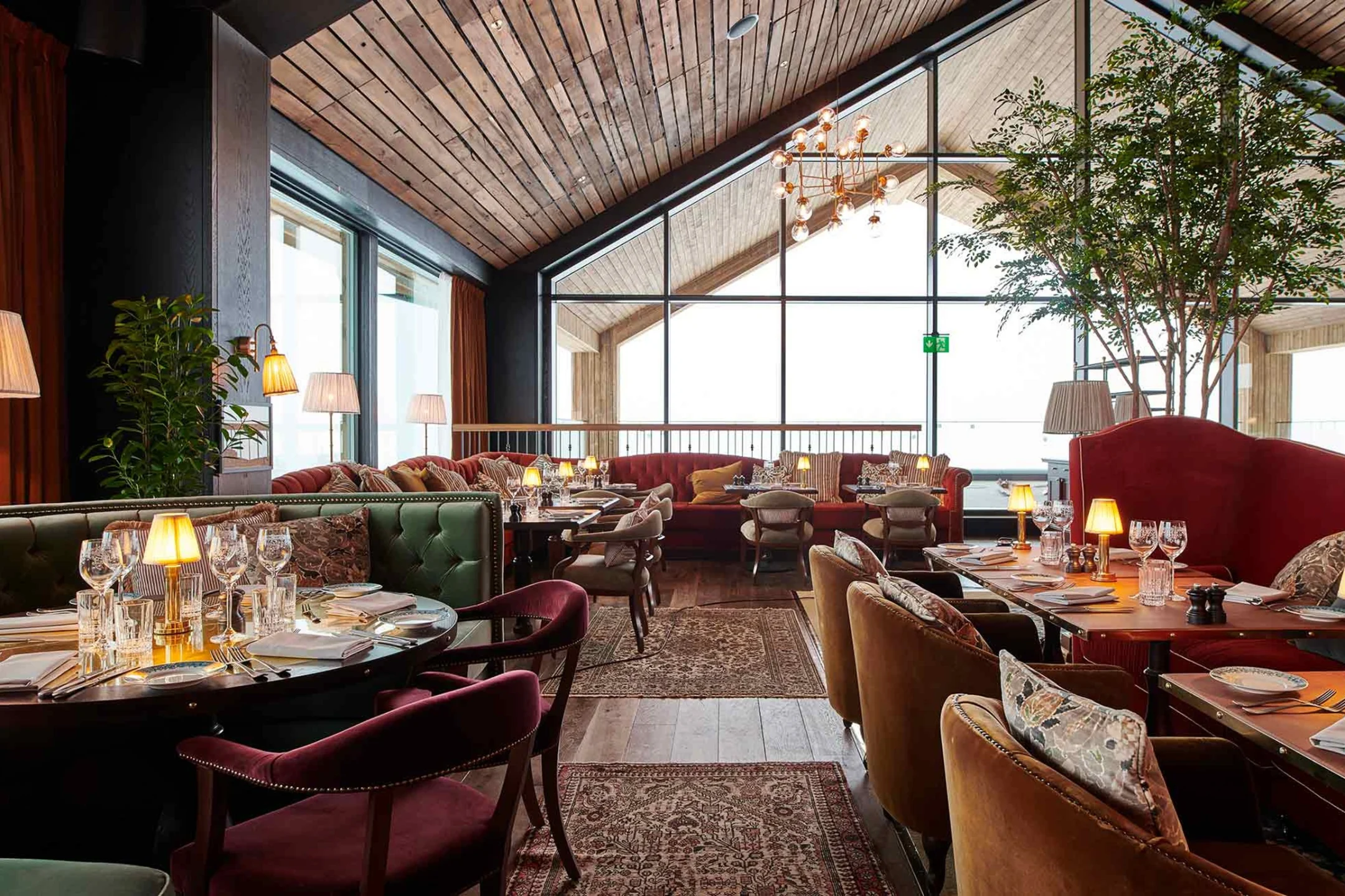 Elegant restaurant interior at a Norwegian resort, featuring stylish furnishings, panoramic windows, and a cozy atmosphere.